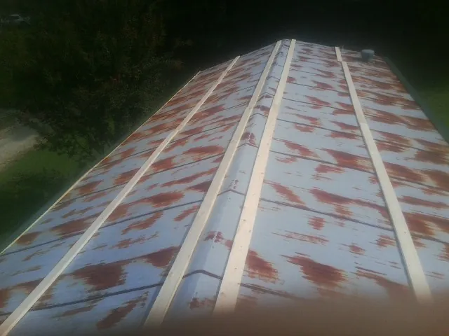 Rusted metal roof panels with new wood purlins before replacement — Storm Damage Roof Repair in Spring Hope by Roofing Brothers