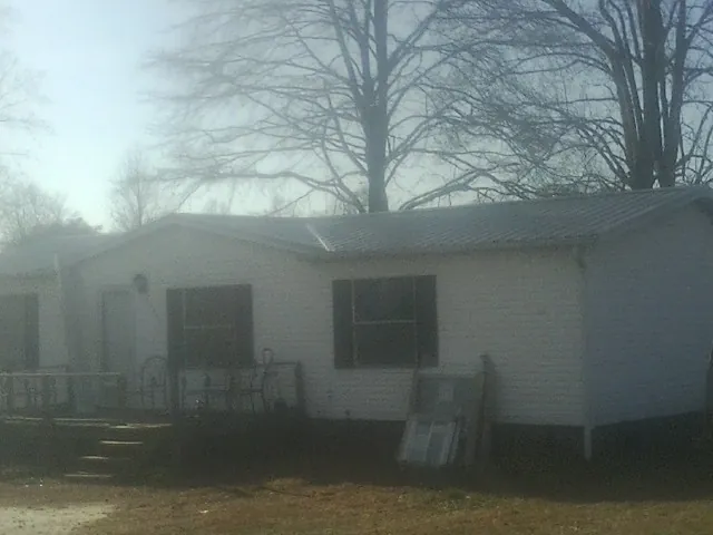 New metal roof on a white painted brick home on a foggy morning in Spring Hope