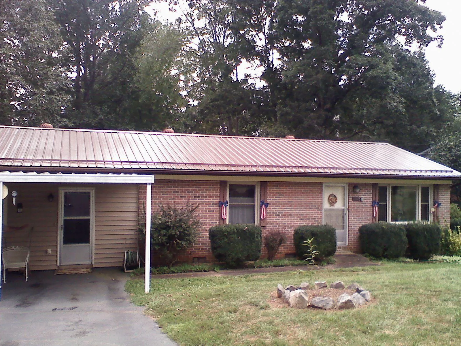 Bronze metal roof and carport on a brick ranch home — Roof Repair work by our crew in Spring Hope